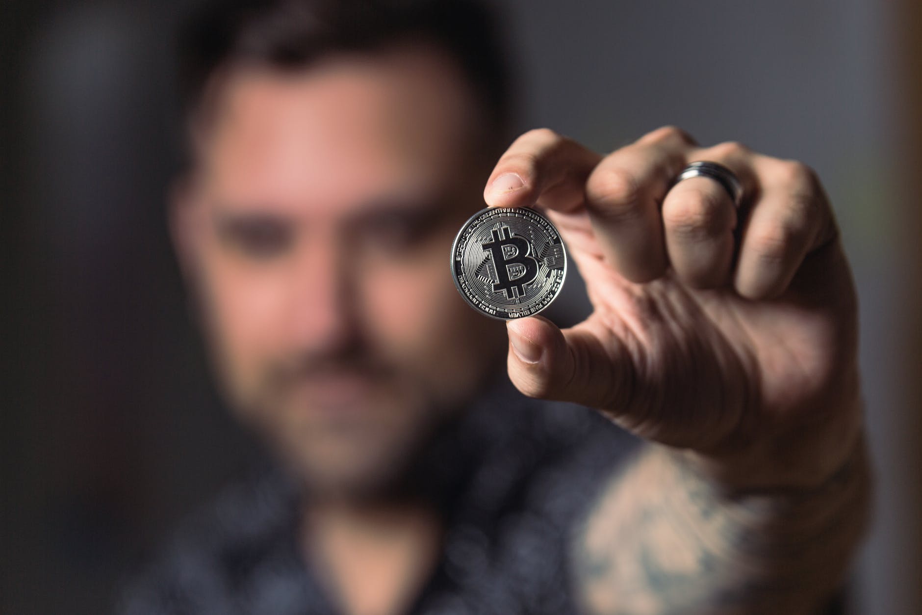 person gambling with silver bitcoin coin