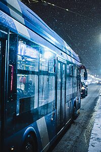 blue bus driving in snowy weather
